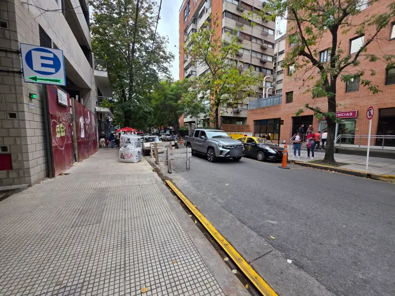 Calle Montañeses: a un lado la entrada del edificio, enfrente FLENI