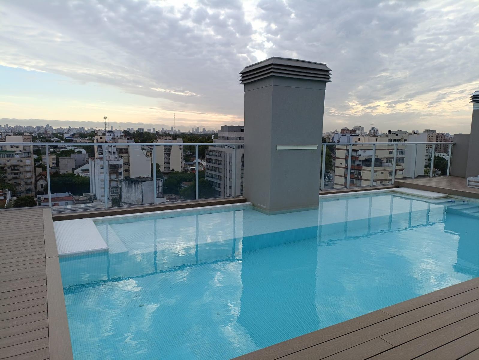 Pileta en la azotea de un edificio en Buenos Aires con vista al skyline al atardecer